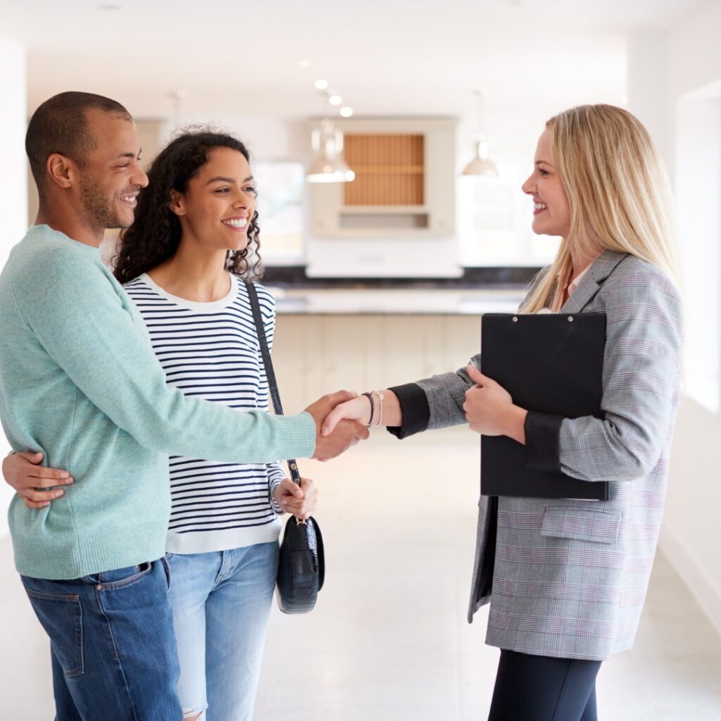realtor shaking hands with new home owners